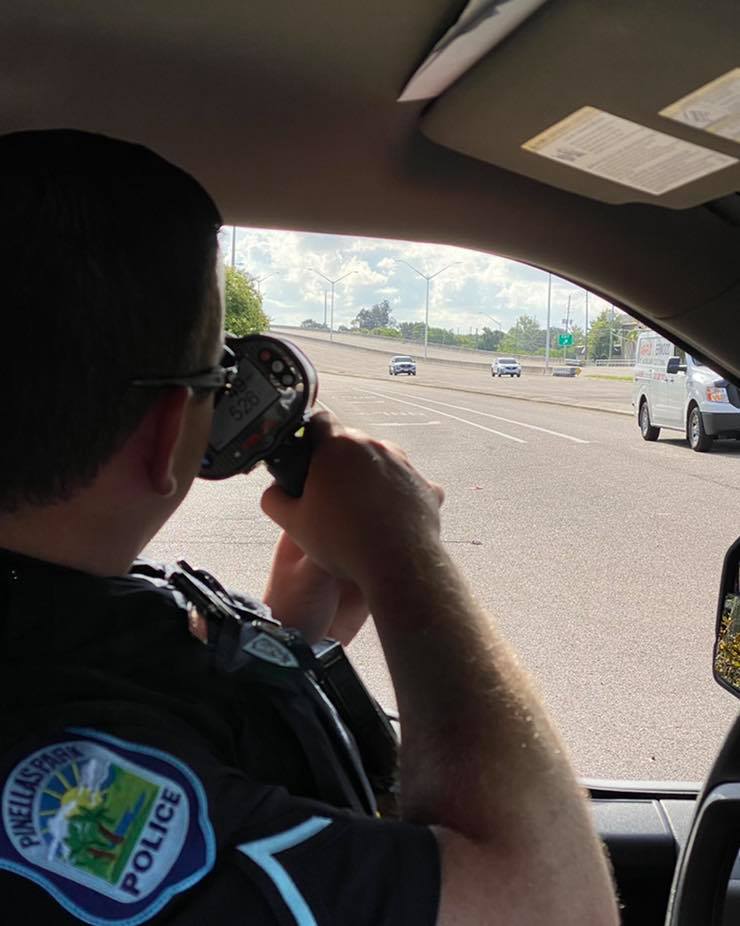 officer with laser speed gun tracking vehicles